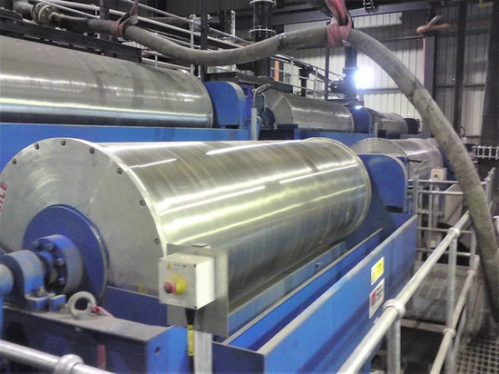 High-quality overall view of a magnetic drum separator operating in an industrial setting.
